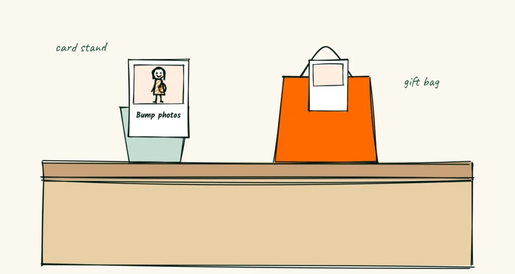 A card for small counters A doodle postcard-size maternity card in a small stand on a boutique counter, next to a gift bag with one card peeking out